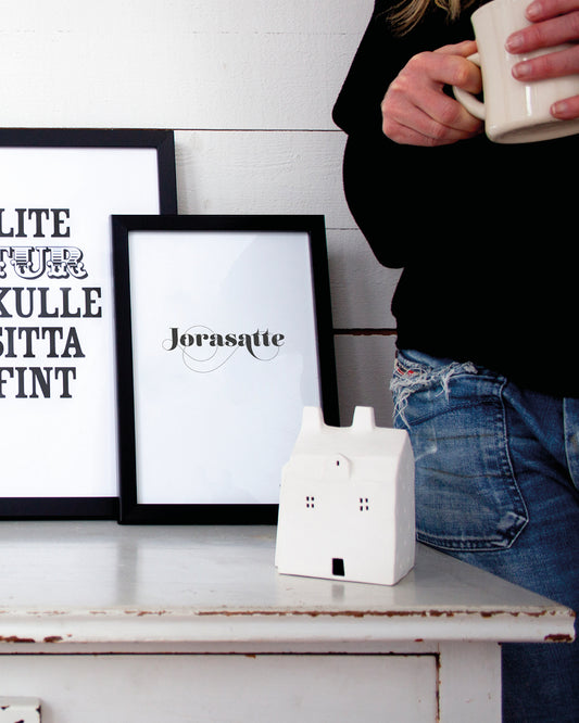 Poster med svenska citatet "Jorasatte" på bord.