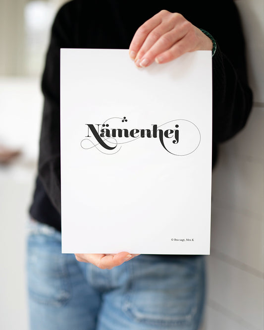 Mrs K håller upp poster med svenska citatet "Nämenhej".