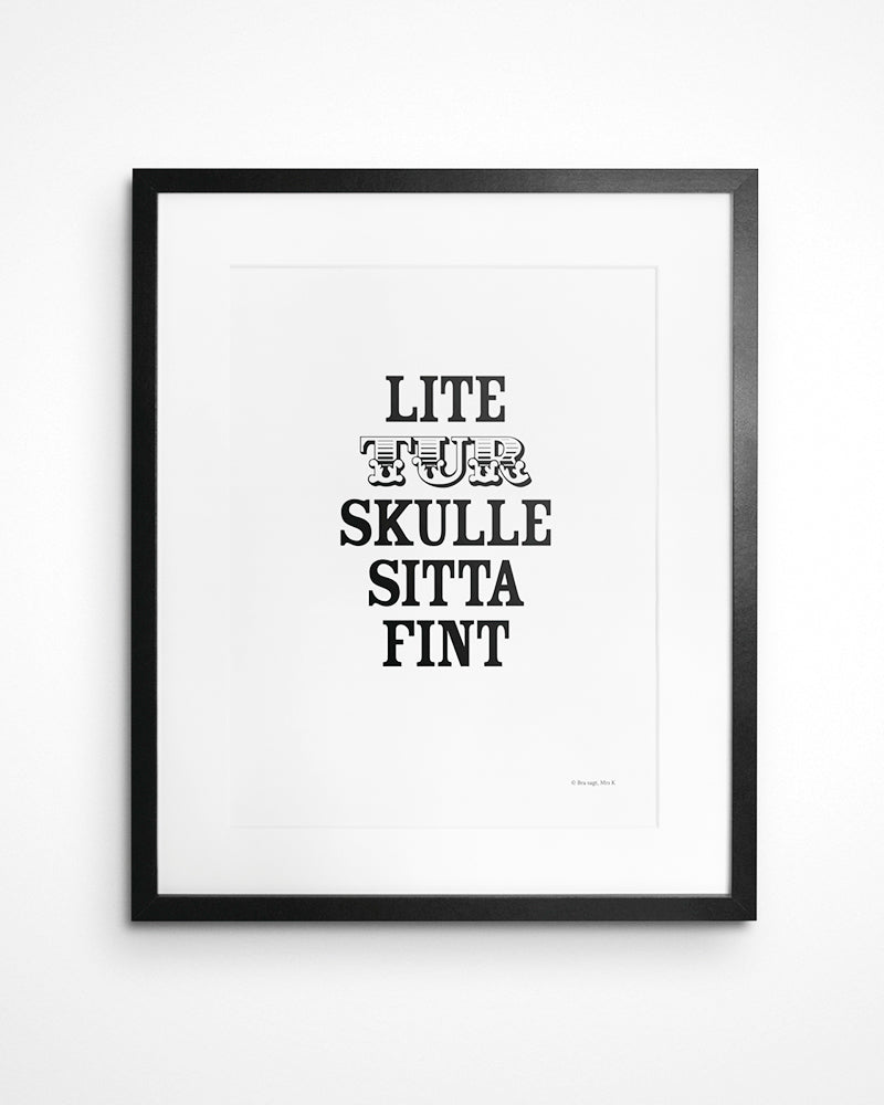 Poster med svenska citatet "Lite tur skulle sitta fint" i ram på vägg. 